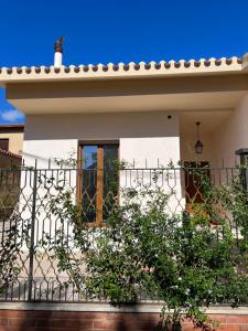 a white house with a fence at Il Nido in Teulada