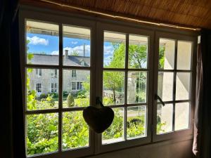 a window with a heart in front of it at Chambres d'Hôtes Manoir Du Chêne in Nonant