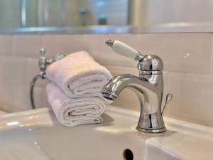 a bathroom sink with a faucet and towels at Pensiunea DolceVita in Măldăreşti +59 photos