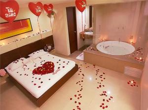 a bathroom with red hearts on the floor and a tub at Hotel Romanza in Medellín