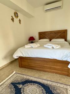 a bedroom with a large bed with a wooden headboard at Betul Guest House in Famagusta