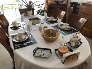 una mesa con un mantel blanco con comida. en Chez Yolande, en Lampaul-Plouarzel