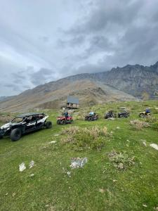 a group of vehicles parked on a grassy hill at mood villa Kazbegi in Stepantsminda