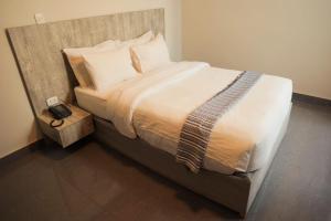 1 dormitorio con 1 cama grande y cabecero de madera en SM Low Cost Bussines Hotel, en Piura