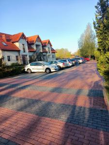 a row of cars parked on a brick road at Kalski Dworek in Węgorzewo