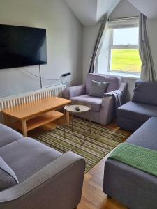a living room with a couch and a table at Portrush by the Sea - 5 Dunluce Park in Portrush