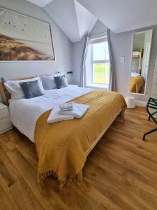 a bedroom with a large bed with a blanket on it at Portrush by the Sea - 5 Dunluce Park in Portrush
