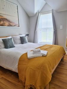 a bedroom with a bed with two towels on it at Portrush by the Sea - 5 Dunluce Park in Portrush
