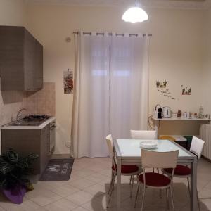 Una cocina con una mesa y sillas y una cortina blanca. en NARBONE 42, en Palermo