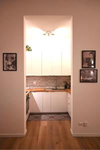 a kitchen with white cabinets and a sink at Maison Bohémienne in Livorno