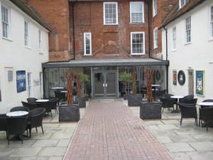 a large brick building with tables and chairs in front of it at The Star and Garter Hotel in Andover