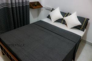 um quarto com uma cama com almofadas e um radiador em Jaya Villa em Negombo