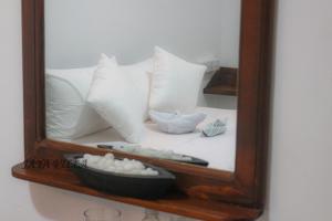 a mirror with white pillows on a bed at Jaya Villa in Negombo