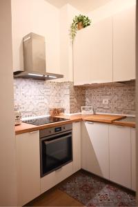 a kitchen with white cabinets and a stove at Maison Bohémienne in Livorno
