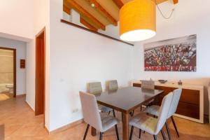 a dining room with a wooden table and chairs at Villa Casa Xaloc in Binibeca