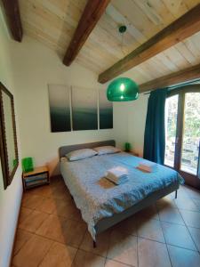 a bedroom with a bed and a green lamp at Rustico del Bozzo in Castelleone di Suasa