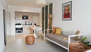 ein Wohnzimmer mit einem Sofa und einer Küche in der Unterkunft CASARICA Aparts in Buenos Aires