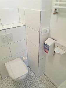 łazienka z toaletą i dozownikiem papieru toaletowego w obiekcie Aparthotel Sanni w Bremie