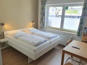 łóżko w pokoju z oknem i stołem w obiekcie Aparthotel Sanni w Bremie