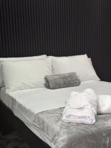 a white bed with white pillows and towels on it at Casa Buen Agüero in San Antonio