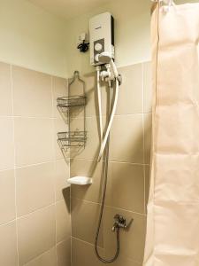 y baño con ducha con cabezal de ducha. en Cozy Pine Suites, en Baguio