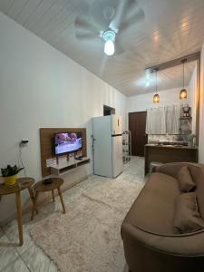 a living room with a couch and a refrigerator at Apart Aconchego Mobiliado até 4 pessoas Centro in Sinop