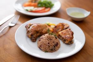een bord met vlees en rijst op tafel bij Pachira Lodge in Tortuguero