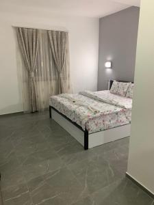 a bedroom with a bed and a tile floor at Hotel Albatros in Prizren