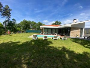 a house with a yard with chairs and a pool at CASA TAPADA DA CHEDA 2 in Celorico de Basto