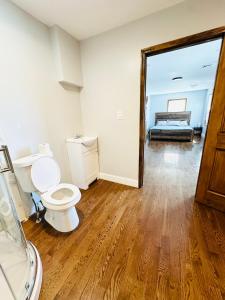 a bathroom with a toilet and a shower and a mirror at Cheerful 4-bedroom home with free parking in Elmont