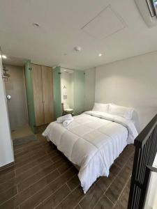 una camera da letto con un grande letto bianco di Apartamento Duplex Centro Histórico a Cartagena de Indias