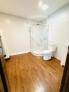łazienka z toaletą i prysznicem w obiekcie Cheerful 4-bedroom home with free parking w mieście Elmont