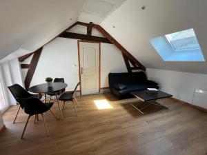 a living room with a black couch and a table at Appartement avec garage in La Ferté-Gaucher