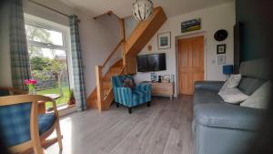 ein Wohnzimmer mit einem Sofa und einem TV in der Unterkunft Lycia Rooms + in Inverness