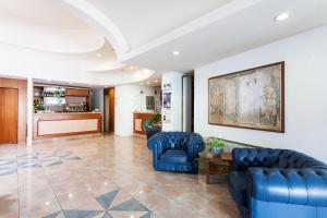 a lobby with two blue chairs and a table at Hotel Los Angeles in Assisi