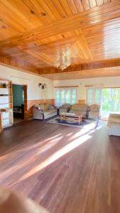 Shangrilla House Murree, Bhurban في مورى: غرفة معيشة كبيرة بسقوف خشبية وأرضية خشبية