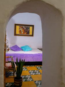 CASA MAGIA by Magally Velasco في كوريتي: غرفة نوم مع سرير وزرع الفخار