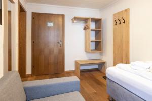 ザールバッハ・ヒンターグレムにあるSki & Bike Hotel Pinzgauerhofのベッドと木製のドアが備わる小さな客室です。