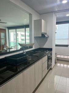 cocina con fregadero y fogones horno superior en Lindo apartamento con vista al mar, en Cartagena de Indias