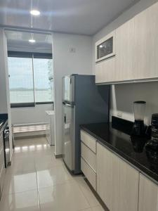 a kitchen with a stainless steel refrigerator and a window at Lindo apartamento con vista al mar in Cartagena de Indias