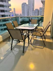einen Tisch und Stühle auf dem Balkon eines Gebäudes in der Unterkunft Lindo apartamento con vista al mar in Cartagena de Indias