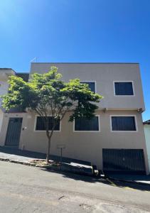 un edificio con un árbol delante de él en Apt térreo com 3 qtos e 1 vaga, en Poços de Caldas