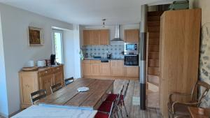a kitchen with a wooden table and a dining room at La bergerie d'Annie in Privas