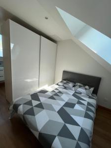 a bedroom with a black and white checkered bed at Appartement avec garage in La Ferté-Gaucher