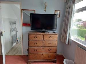 a television on top of a dresser in a room at Double room with ensuite shower room in quiet, private house in Worthing