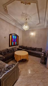 un soggiorno con tavolo e lampadario pendente di Villa with riad style a Fes
