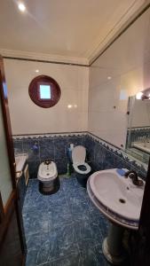 bagno con lavandino, servizi igienici e specchio di Villa with riad style a Fes