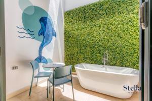 uma casa de banho com um mural de sereia azul ao lado de uma banheira em A Perfect Place em Playa del Carmen