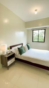 1 dormitorio con 2 camas y ventana en Cozy Pine Suites, en Baguio