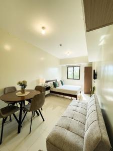 Sala de estar con sofá, cama y mesa en Cozy Pine Suites, en Baguio